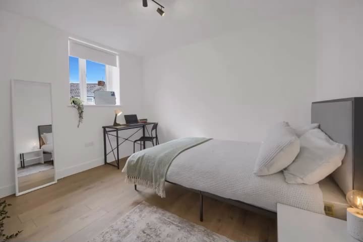 HMO bedroom with double bed, desk and oak-effect floor