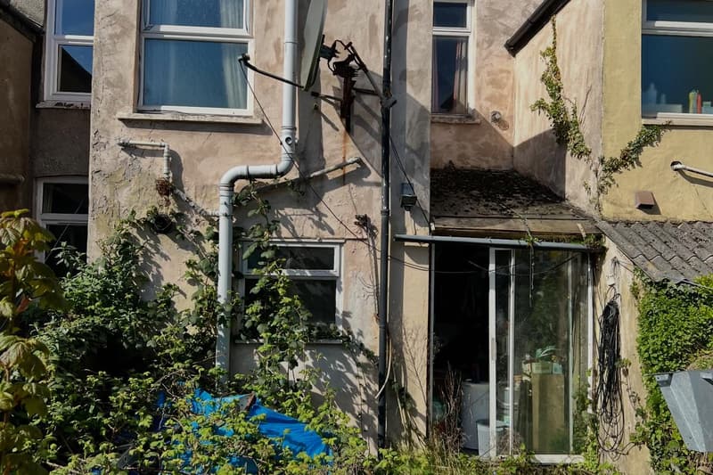 Overgrown rear elevation of the Cathays house before the rear extension