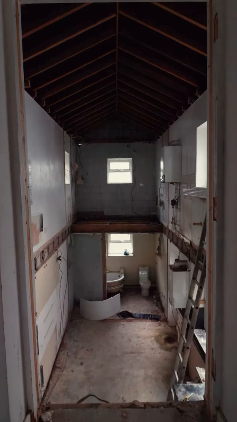 Stripped-back hallway and roof structure during the rip-out